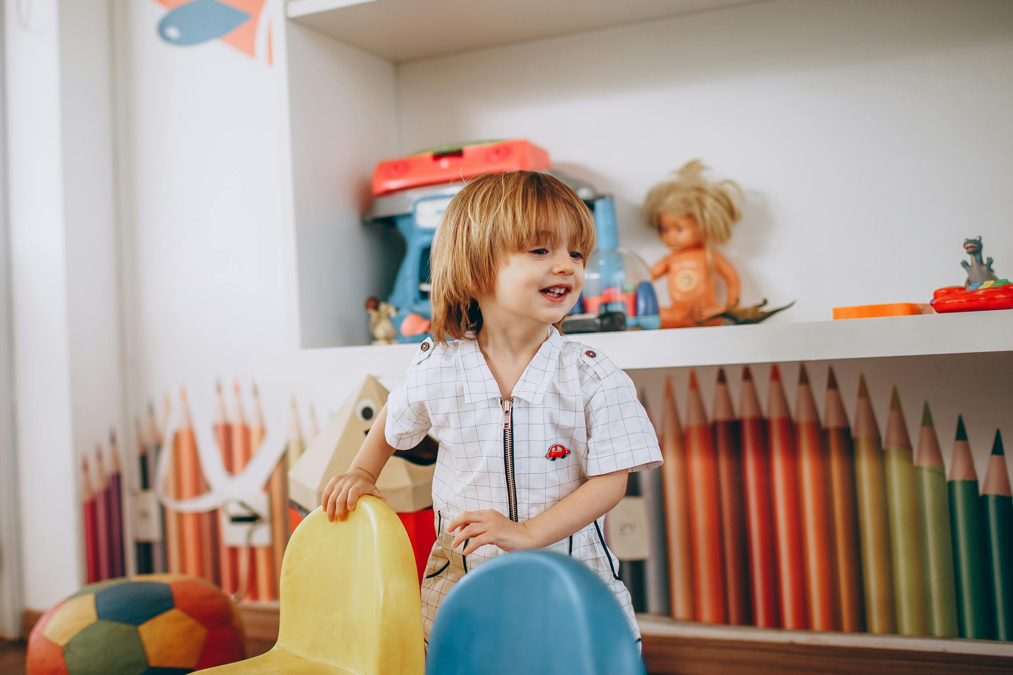 Smiling child enjoys playtime in a vibrant, creative preschool classroom environment.